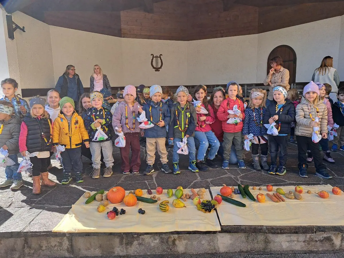 Kinder und Erwachsene feiern das Erntedankfest im Pavillon.