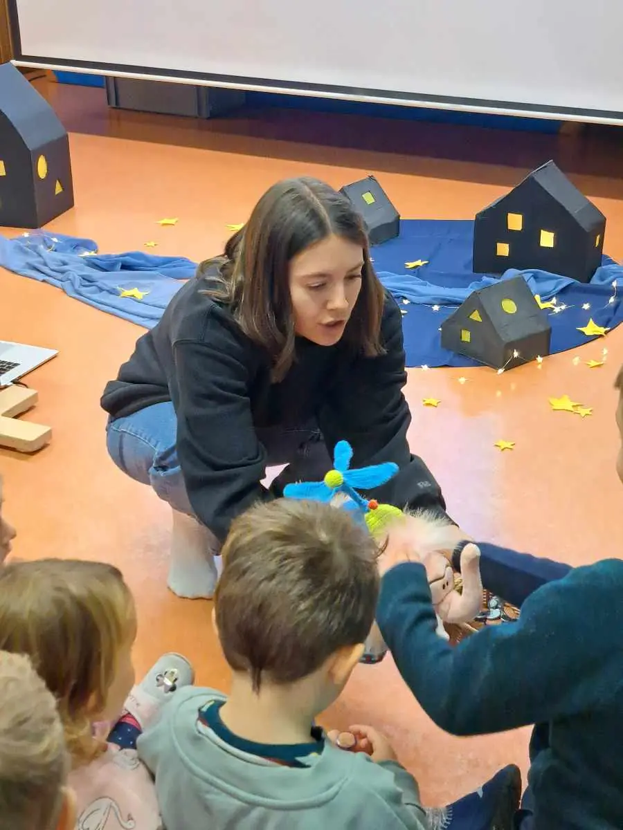 Die Kinder hören bei der Vorstellung des Bilderbuchs zu.